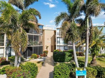 Building entrance with lush landscaping and signage at 618 Bird Bay S Dr # 201, Venice, FL 34285