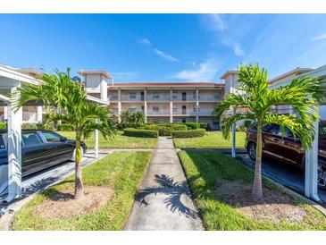 Condo building with palm trees, walkway, and parking at 6505 Stone River Rd # 202, Bradenton, FL 34203