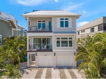 Two-story house featuring a modern design, two-car garage, and a metal roof at 106 9Th S St, Bradenton Beach, FL 34217