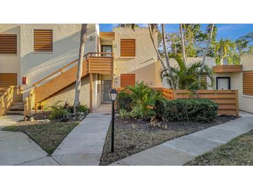 Exterior view of condo building showcasing landscaping and walkway at 144 Wild Palm Dr, Bradenton, FL 34210
