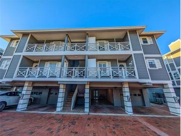 Three-story building with gray siding, balconies, and parking at 1552 Stickney Point Rd # 403, Sarasota, FL 34231