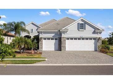 Two-story house with gray siding, white garage doors, and a paved driveway at 21536 Palatka Dr, Venice, FL 34293