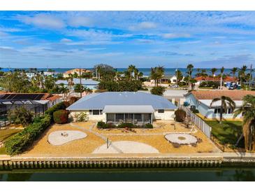 Aerial view of canal-front home with spacious backyard and patio at 606 Gladstone Ln, Holmes Beach, FL 34217