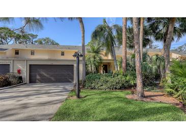 Exterior of charming condo with attached garage and lush landscaping at 7938 Pinegrove Ct # 12, Sarasota, FL 34238