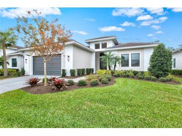 Single-story home with gray garage door and landscaped yard at 9085 Bernini Pl, Sarasota, FL 34240