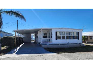 White mobile home with carport, landscaping, and storage shed at 10315 Cortez W Rd # 37F, Bradenton, FL 34210