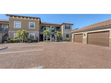Two-story condo building with parking and tropical landscaping at 12413 Osorio Ct # 103, Sarasota, FL 34238