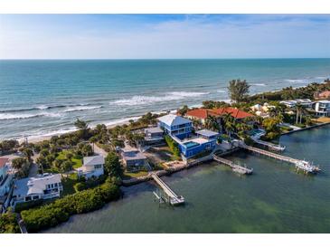 Aerial view of waterfront home with private dock, ocean access, and lush landscaping at 1620 Casey Key Rd, Nokomis, FL 34275