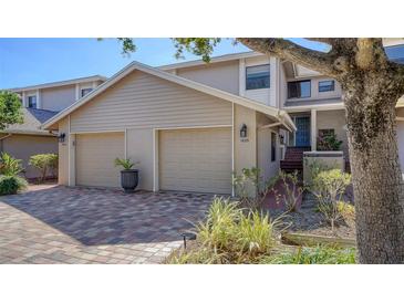 Tan two-story home with two-car garage and landscaped front yard at 1620 Starling Dr # 204, Sarasota, FL 34231