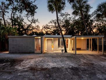 Mid-century modern home with carport and tropical landscaping at 1695 Lowe Dr, Sarasota, FL 34236