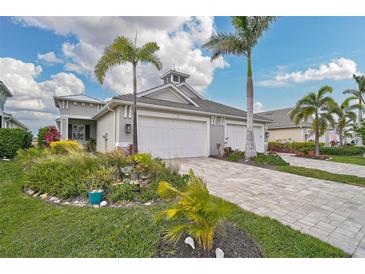 Two-car garage, paver driveway, and lush landscaping at 192 Van Gogh Cv, Bradenton, FL 34212