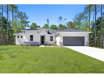 Single-story home with gray garage and stone accents at 3490 Ikola Ave, North Port, FL 34288