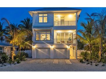 Two-story home with a modern design, two-car garage, and palm trees at 105 6Th S St, Bradenton Beach, FL 34217