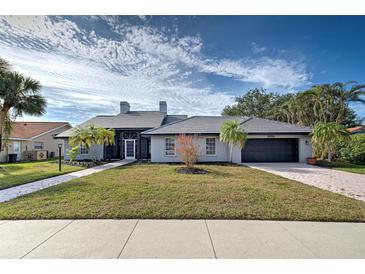 Single-story home with gray exterior, tile roof, and landscaped yard at 1051 Truman St, Nokomis, FL 34275