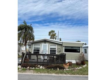 Mobile home with deck and tropical landscaping at 2601 Gulf N Dr # 510, Bradenton Beach, FL 34217
