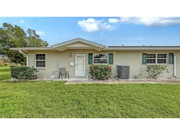 Tan house with green accents, landscaping, and a spacious lawn at 2621 Golf Course Dr # 401, Sarasota, FL 34234