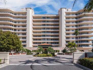 Elegant high-rise building with palm trees and courtyard at 3060 Grand Bay Blvd # 113, Longboat Key, FL 34228