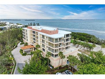 Aerial view of a luxurious waterfront condo building with lush landscaping at 3080 Grand Bay Blvd # 544, Longboat Key, FL 34228