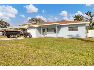 House with a green lawn, white garage, and light blue exterior at 3231 Yorktown St, Sarasota, FL 34231