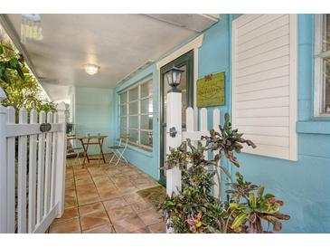 Inviting front patio with tiled flooring, white picket fence, and small table at 418 Sarabay Rd, Osprey, FL 34229