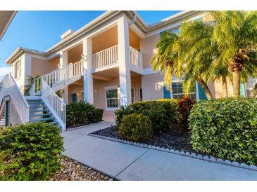 Two-story condo building with lush landscaping and a walkway at 4202 Caddie E Dr # 102, Bradenton, FL 34203