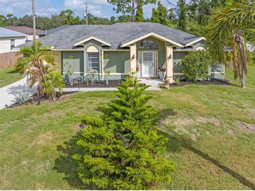 Single-story home with green exterior, landscaping, and driveway at 5375 Joslyn Ter, Port Charlotte, FL 33981