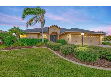 Tan house with lush landscaping, double garage, and palm tree at 9100 Yarberry St, Sarasota, FL 34240