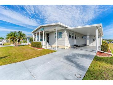 Single-wide manufactured home with carport and landscaped yard at 1108 43Rd Avenue E Dr, Ellenton, FL 34222