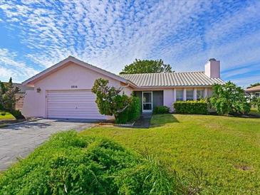 Pink single-story house with a well-maintained lawn and attached garage at 1314 64Th W St, Bradenton, FL 34209