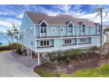 Three-story waterfront home with light blue siding, and a two-car garage at 16 Tidy Island Blvd # 16, Bradenton, FL 34210