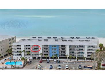 Aerial view of beachfront condo building with parking and pool at 19610 Gulf Blvd # 303, Indian Shores, FL 33785