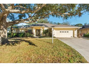 Single-story house with two-car garage and mature oak tree providing shade at 3298 Branch Creek Dr, Sarasota, FL 34235