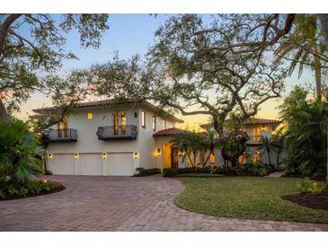 Luxury waterfront home with three-car garage, mature landscaping, and brick driveway at 3930 Red Rock Way, Sarasota, FL 34231