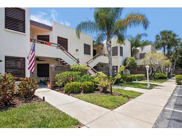 Exterior view of condo building with lush landscaping and walkway at 401 Spring Lakes Blvd # 401, Bradenton, FL 34210