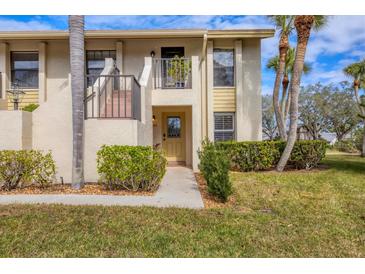 Two-story condo building with lush landscaping and palm trees at 4402 Weybridge St # 95, Sarasota, FL 34235