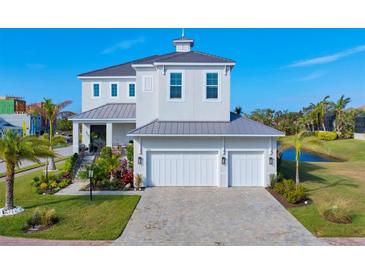 Two-story home with gray metal roof, white siding, and two-car garage at 5204 Title Row Dr, Bradenton, FL 34210