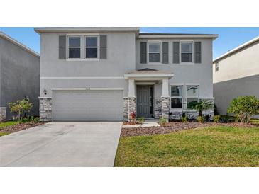 Two-story house with gray siding, stone accents, and a two-car garage at 5216 Adega Way, Bradenton, FL 34211