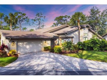 Inviting home exterior featuring a paved driveway and lush landscaping at 5625 Pipers Waite # 9, Sarasota, FL 34235