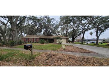 Brick ranch home with attached garage and mature landscaping at 616 Pawn Way, Seffner, FL 33584