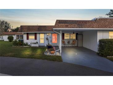 Inviting condo exterior featuring a covered carport and well-maintained landscaping at 680 Circlewood Dr # W3, Venice, FL 34293