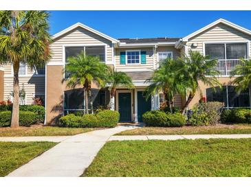 Tan two-story townhome with palm trees and a walkway at 8932 Manor Loop # 207, Lakewood Ranch, FL 34202