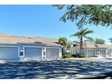 Exterior view of condo building with attached garages and landscaping at 9499 Millbank Dr # 2721, Sarasota, FL 34238