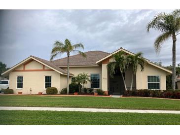 Single-story home with tile roof, landscaping, and palm trees at 1144 Hoover St, Nokomis, FL 34275