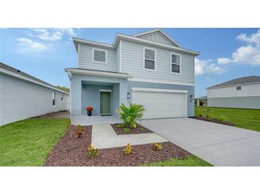 Two-story light blue house with a two-car garage and landscaping at 13014 Bayberry Way, Parrish, FL 34219