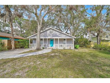 Charming gray house with a bright blue door and a well-maintained lawn at 1335 12Th St, Sarasota, FL 34236