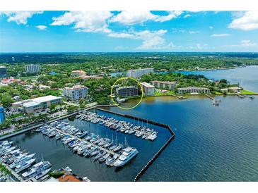 Aerial view of waterfront condo building with marina and city skyline in background at 1510 1St W Ave # 303, Bradenton, FL 34205