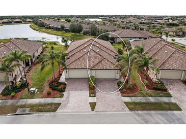 Aerial view of two-unit home with tile roofs, two-car garages, and landscaped yards at 20289 Benissimo Dr, Venice, FL 34293