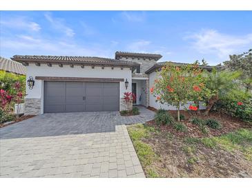 Charming single-story home featuring a paved driveway, gray garage door, and well-manicured landscaping at 328 Aria Dr, Nokomis, FL 34275