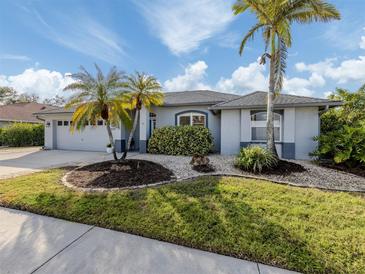 Single-story home with landscaped yard, two-car garage, and palm trees at 4584 Country Manor Dr, Sarasota, FL 34233