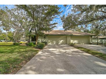 House exterior showcasing a light-green two-car garage and manicured lawn at 4655 Pine Green Trl # 24, Sarasota, FL 34241